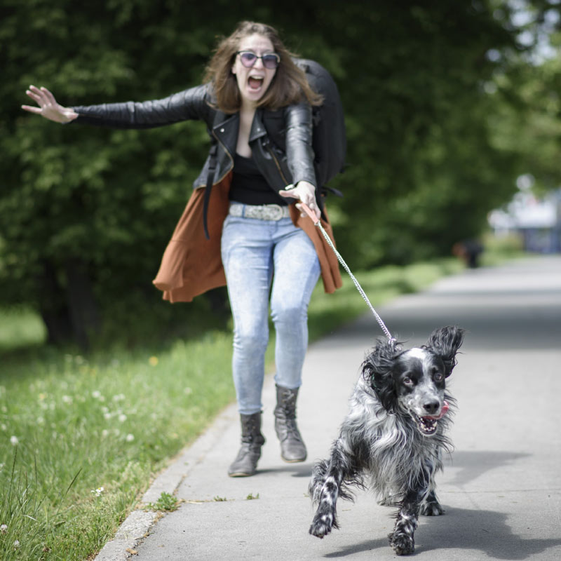 young woman pulled by young dog on leash